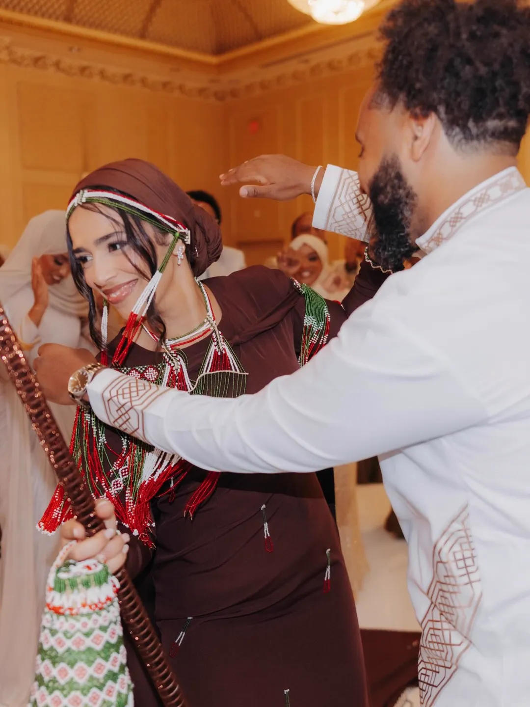 A bride and groom dancing during their ceremony, guests cheering behind